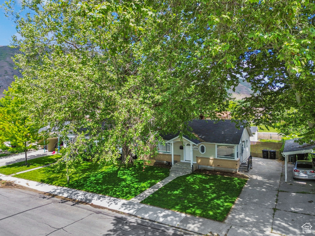 View of front of property with brick siding, a front yard, and concrete driveway