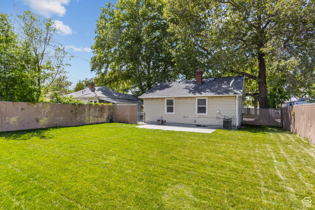Rear view of house with a patio area, a chimney, and cooling unit