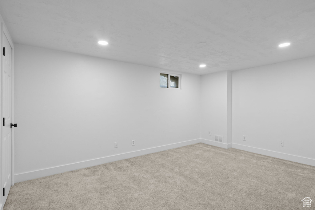 Below grade area featuring recessed lighting, light colored carpet, and baseboards