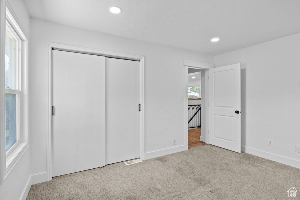 Unfurnished bedroom with carpet, recessed lighting, baseboards, and a closet