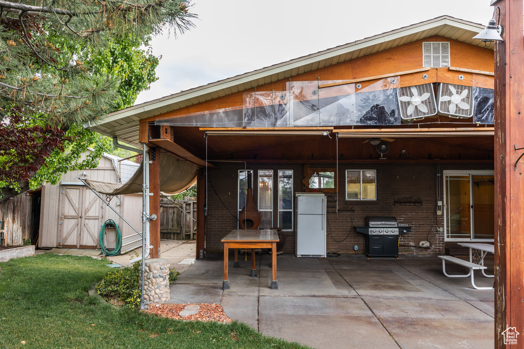 Rear view of property featuring a patio area and brick siding
