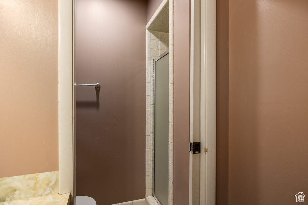 Bathroom featuring a shower stall and toilet