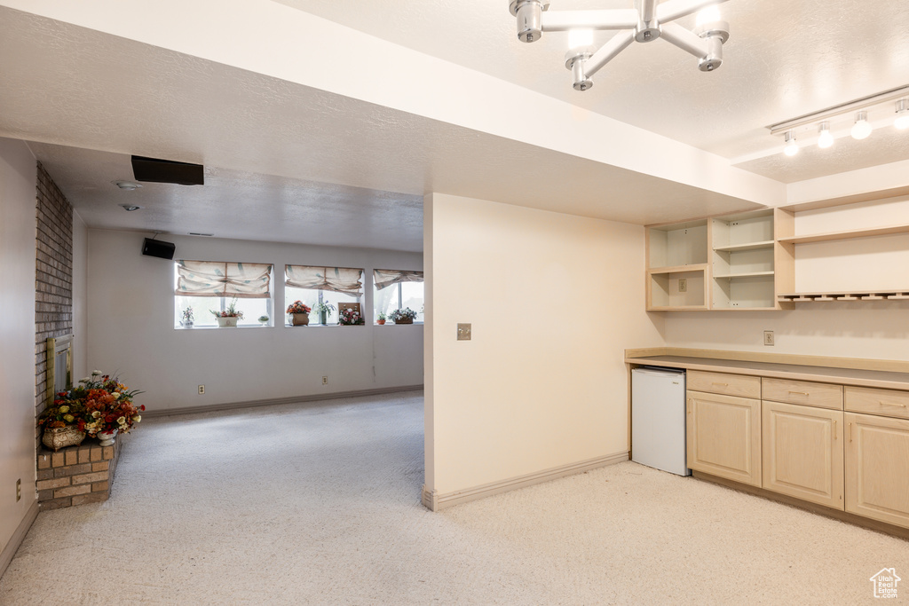 Kitchen featuring baseboards, refrigerator, and a chandelier