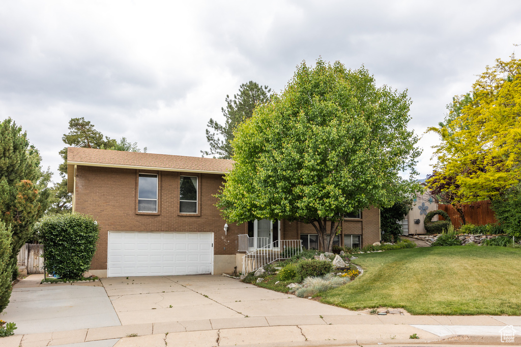 View of front of house featuring a garage, brick siding, and driveway