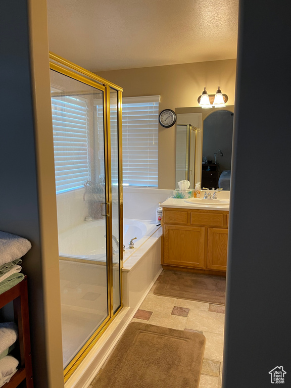 Full bathroom with a stall shower, vanity, and a bath