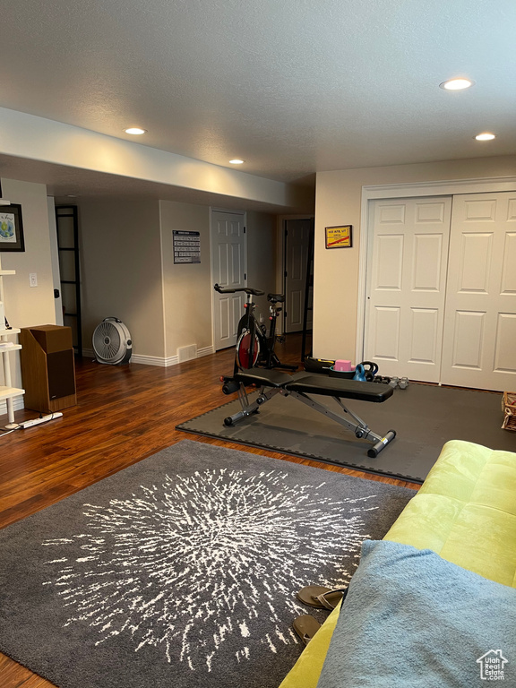 Exercise room with wood finished floors, recessed lighting, and baseboards