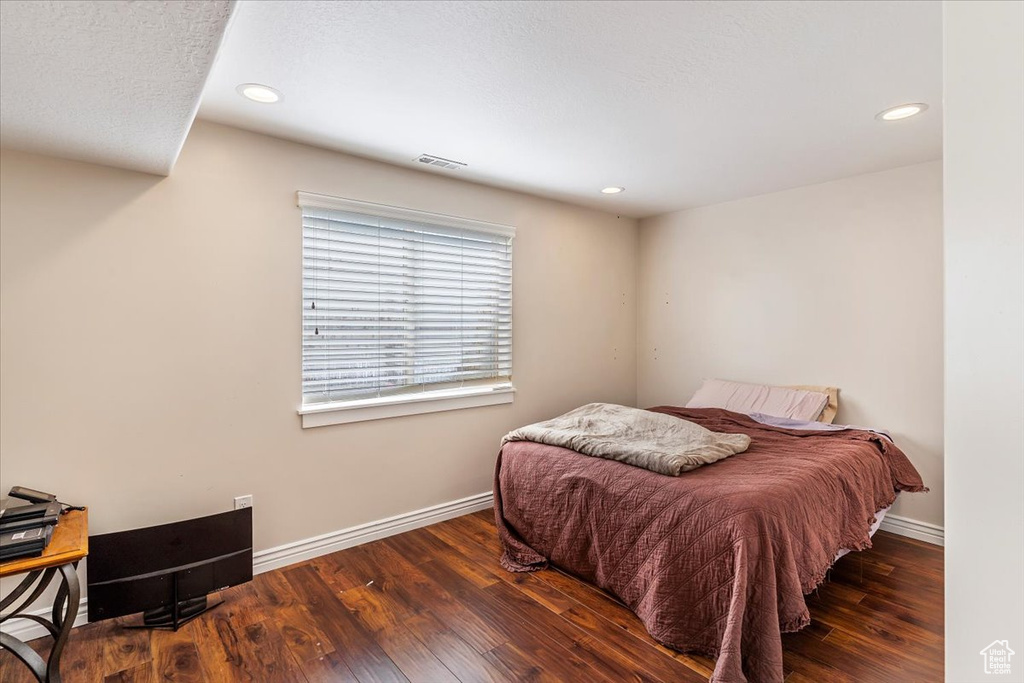 Bedroom featuring wood finished floors, baseboards, and recessed lighting