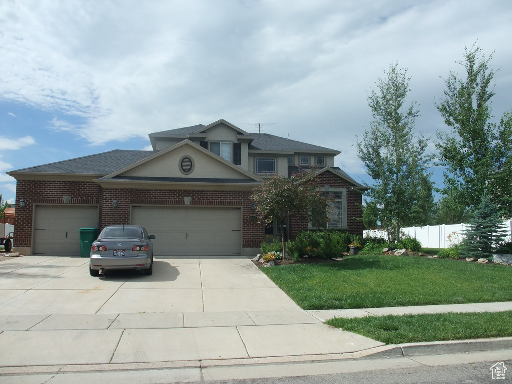 Traditional-style home with an attached garage, concrete driveway, and brick siding