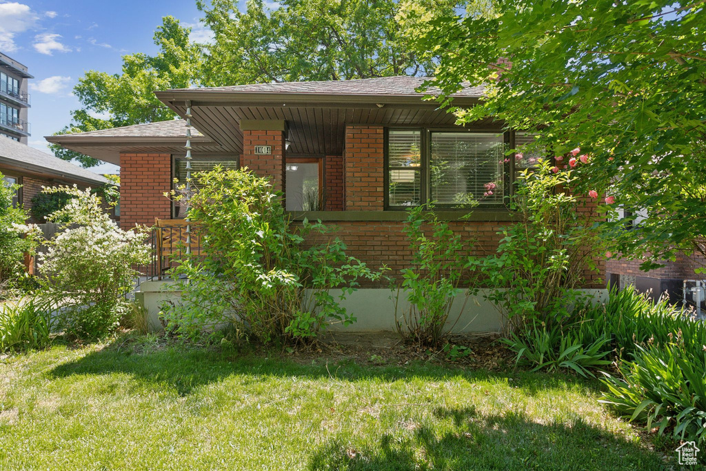 View of front of home featuring brick siding and a front lawn