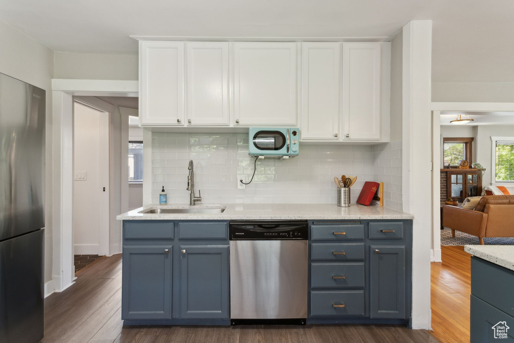 Kitchen featuring stainless steel appliances, a sink, white cabinetry, and dark wood-style floors