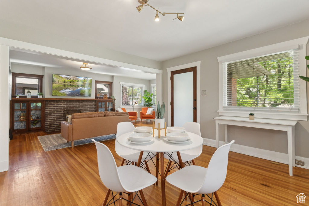 Dining space with light wood-style flooring, baseboards, and a fireplace