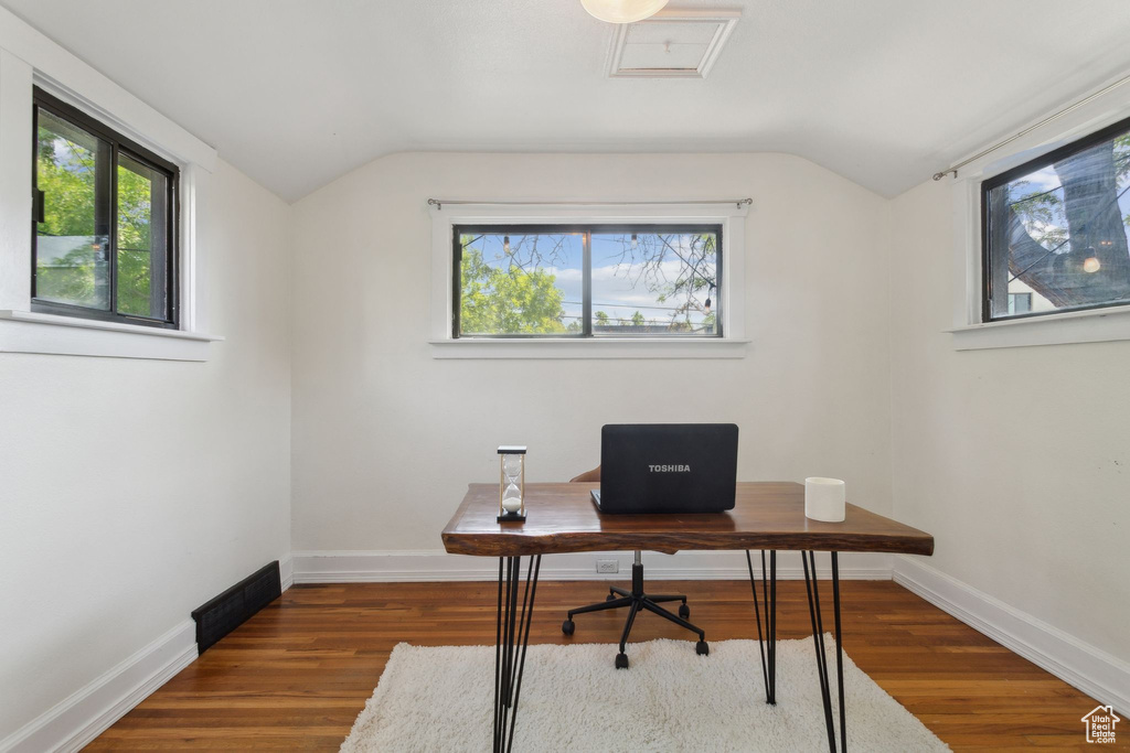 Home office featuring lofted ceiling, plenty of natural light, wood finished floors, and baseboards