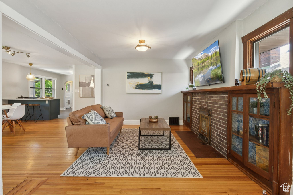 Living area with a brick fireplace and wood finished floors