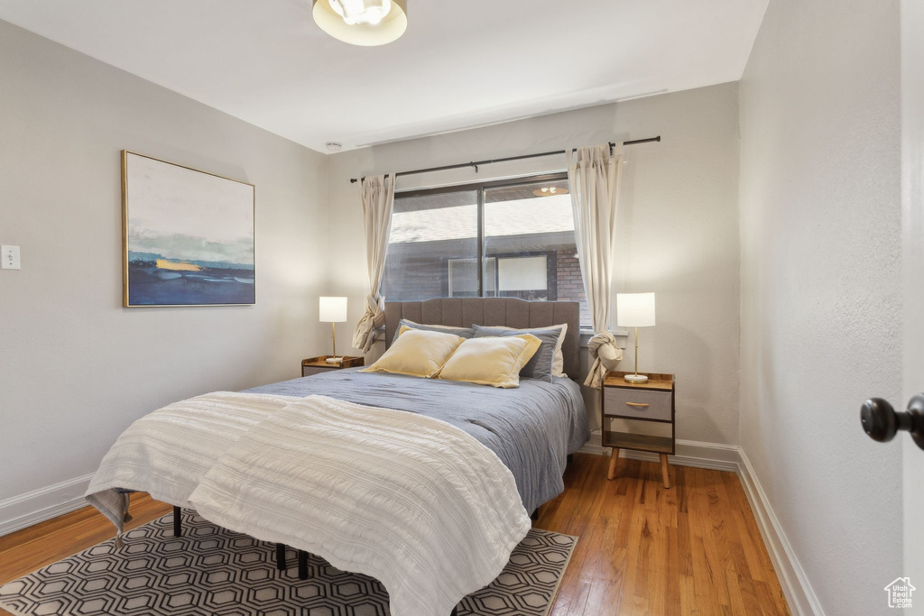 Bedroom with wood finished floors and baseboards