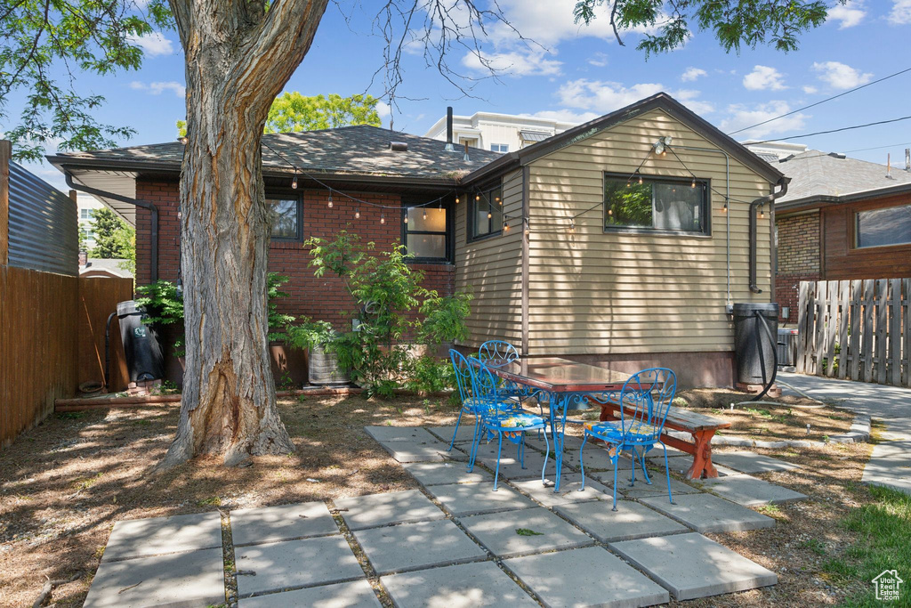 Back of property featuring a patio, brick siding, and outdoor dining area