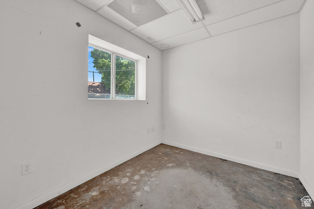 Spare room featuring concrete flooring and baseboards