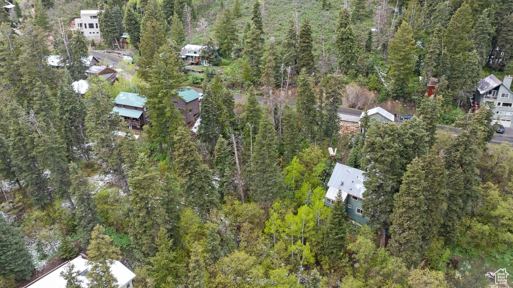 Aerial view of property and surrounding area with a heavily wooded area