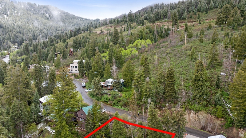 View of property location featuring property parcel outlined, a heavily wooded area, and mountains