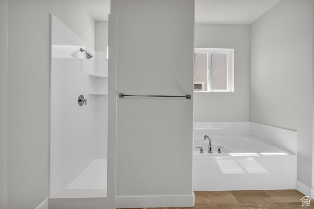 Full bathroom with a shower, a bath, and wood finished floors