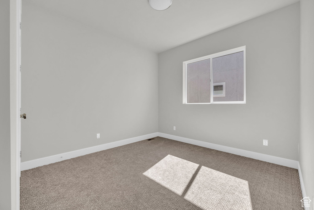Empty room with carpet flooring and baseboards