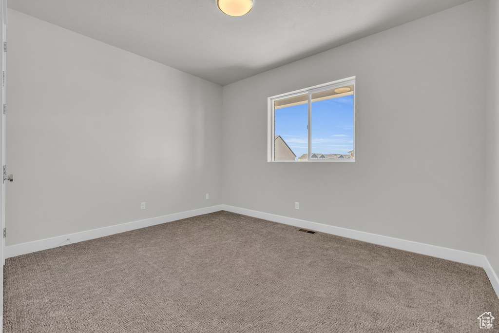Carpeted empty room featuring baseboards