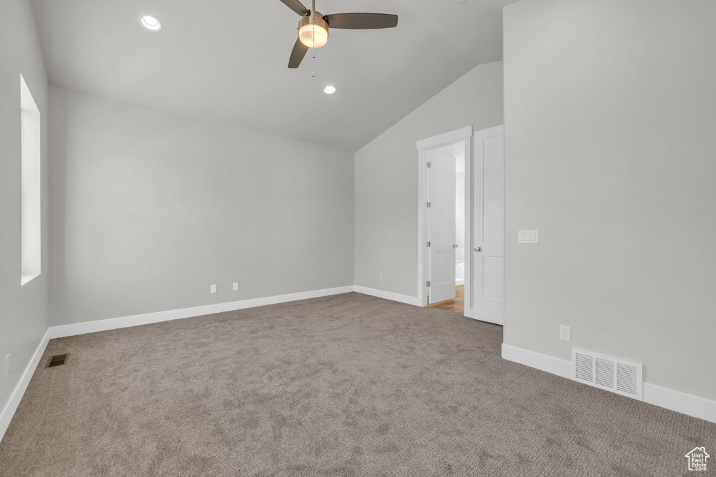 Carpeted spare room featuring ceiling fan, vaulted ceiling, baseboards, and recessed lighting