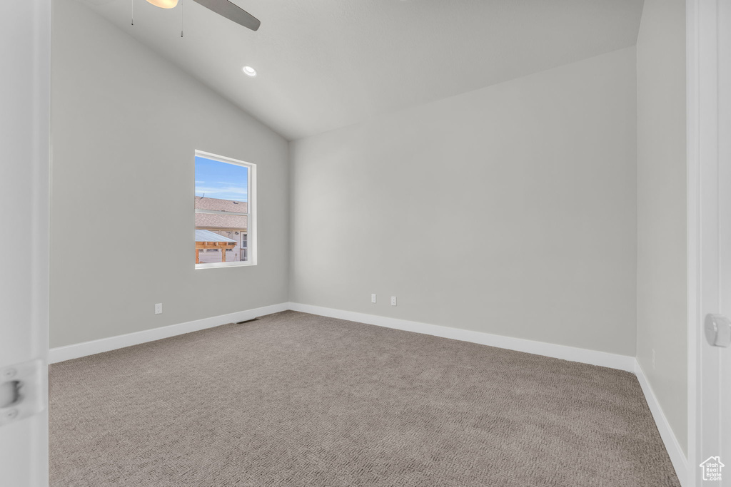 Carpeted spare room featuring vaulted ceiling, ceiling fan, baseboards, and recessed lighting