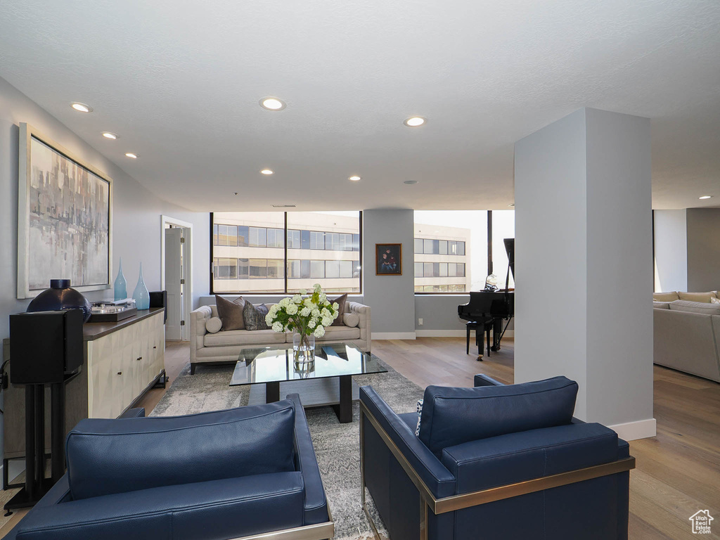 Living area with light wood finished floors, recessed lighting, and baseboards