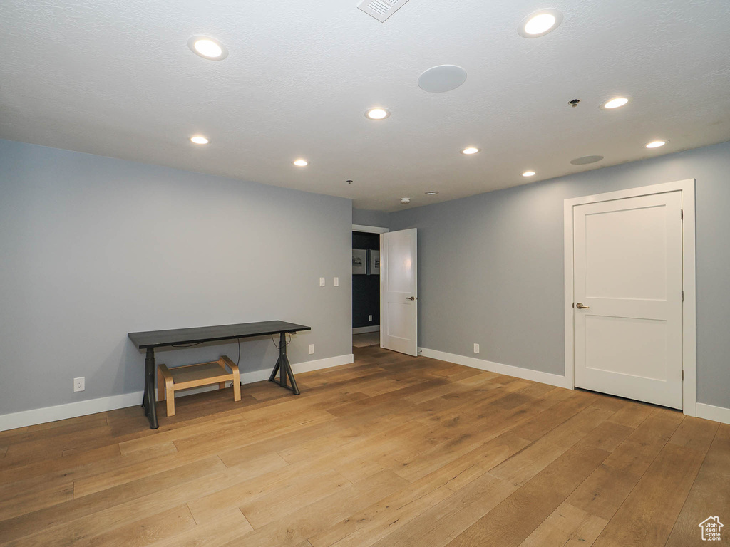 Unfurnished room with baseboards, light wood finished floors, and recessed lighting