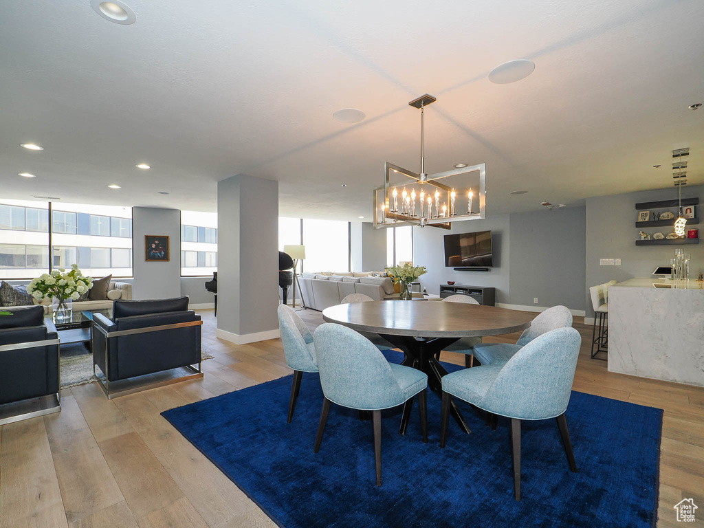 Dining area featuring wood finished floors, a chandelier, baseboards, and recessed lighting
