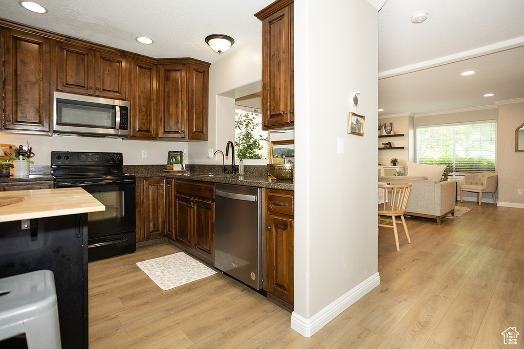 Kitchen featuring stainless steel appliances, light wood-style floors, a sink, recessed lighting, and baseboards