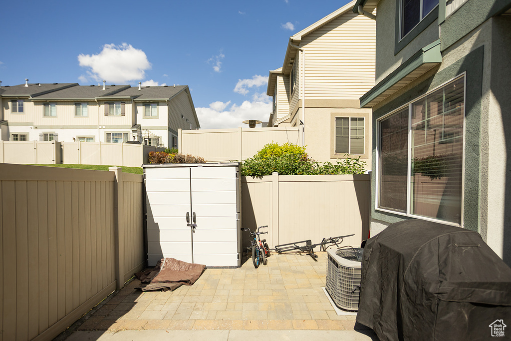 Fenced backyard featuring a patio, grilling area, and a residential view