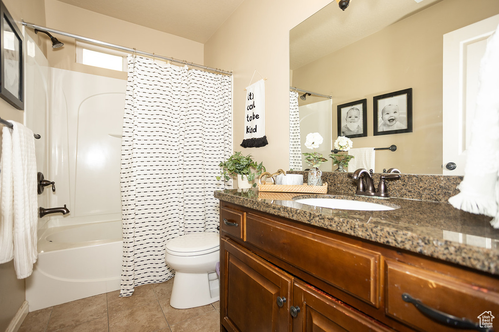 Full bathroom with toilet, vanity, tile patterned floors, and shower / tub combo with curtain