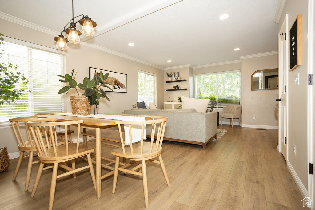 Dining space with light wood finished floors, crown molding, baseboards, and recessed lighting