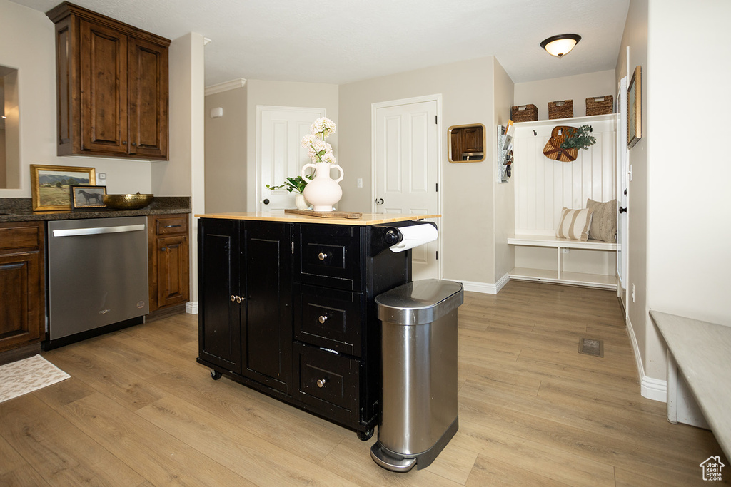 Kitchen featuring stainless steel dishwasher, light wood-style floors, a kitchen island, and baseboards