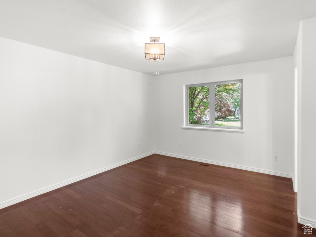 Unfurnished room with dark wood-style flooring and baseboards