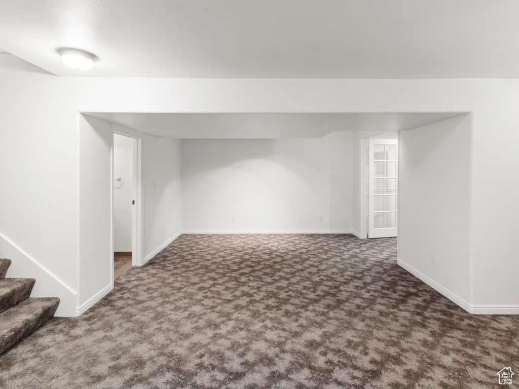 Finished below grade area with carpet floors, baseboards, and stairway