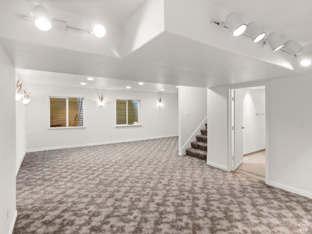 Finished below grade area featuring carpet flooring, stairs, and baseboards