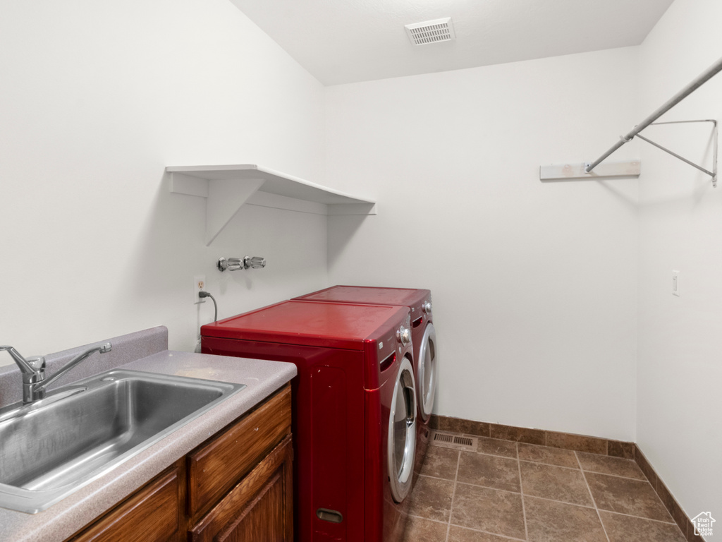 Washroom featuring baseboards, washer and dryer, and cabinet space