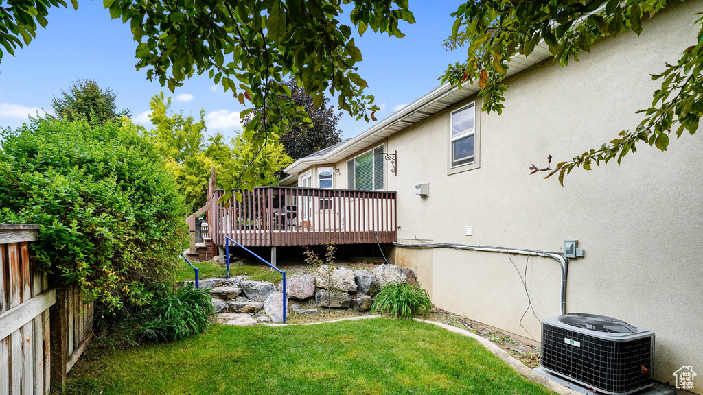 View of yard with central air condition unit and a wooden deck