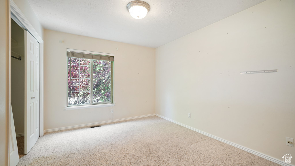 Unfurnished bedroom with light carpet, baseboards, and a closet