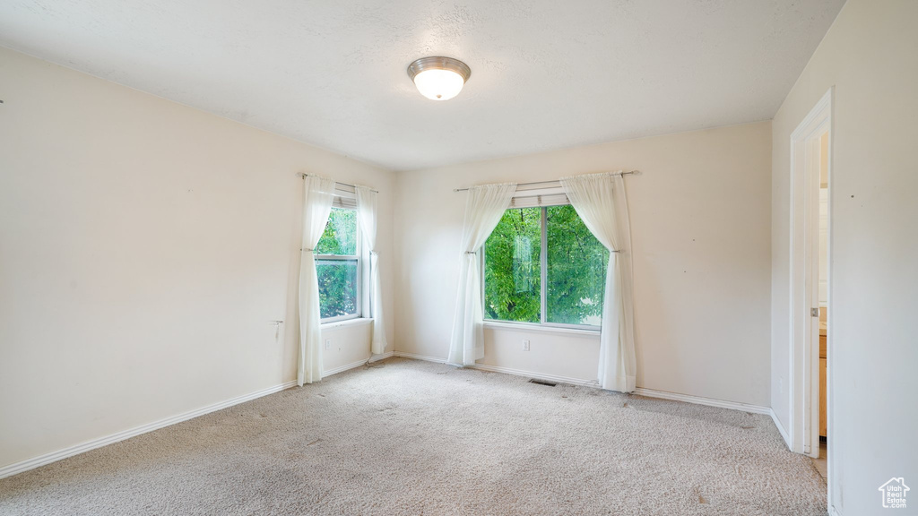Spare room featuring carpet and baseboards