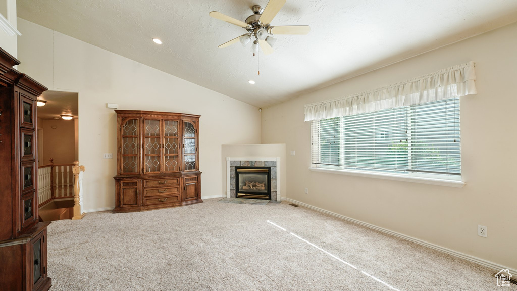 Unfurnished living room featuring a premium fireplace, carpet, ceiling fan, vaulted ceiling, and recessed lighting