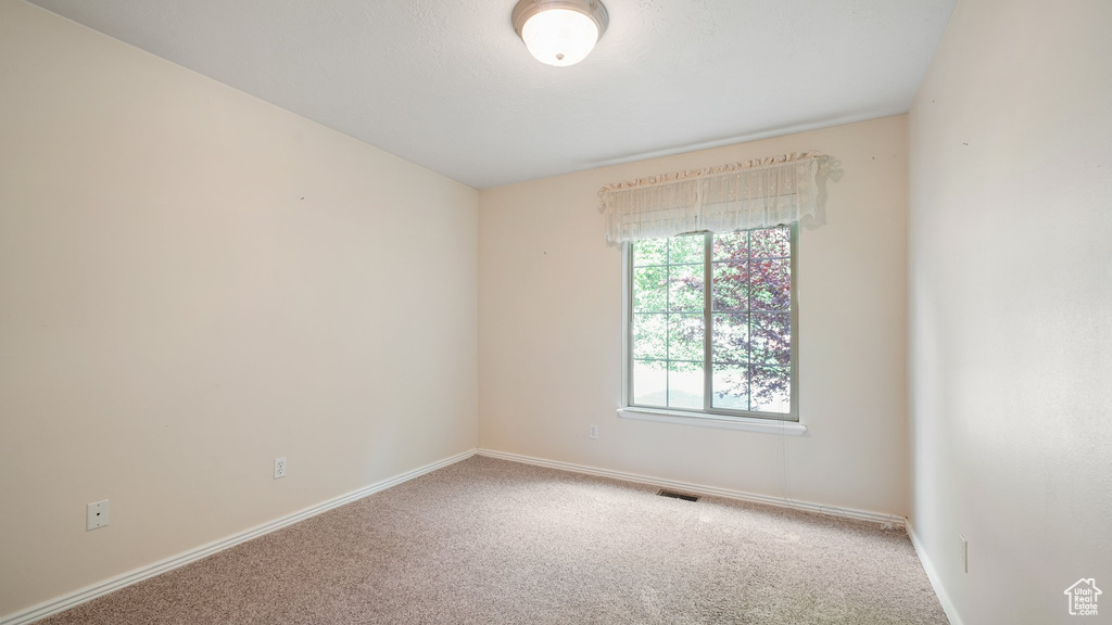 Carpeted empty room featuring baseboards