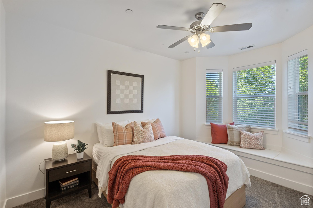 Carpeted bedroom featuring baseboards and ceiling fan