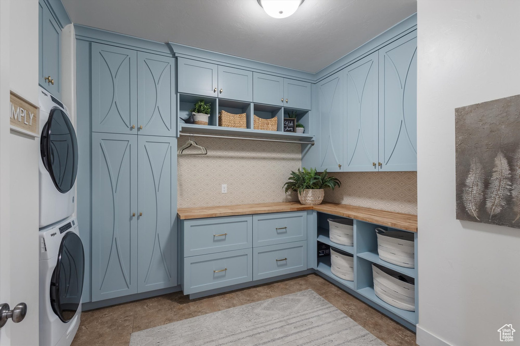 Laundry room featuring estacked washer and dryer and cabinet space