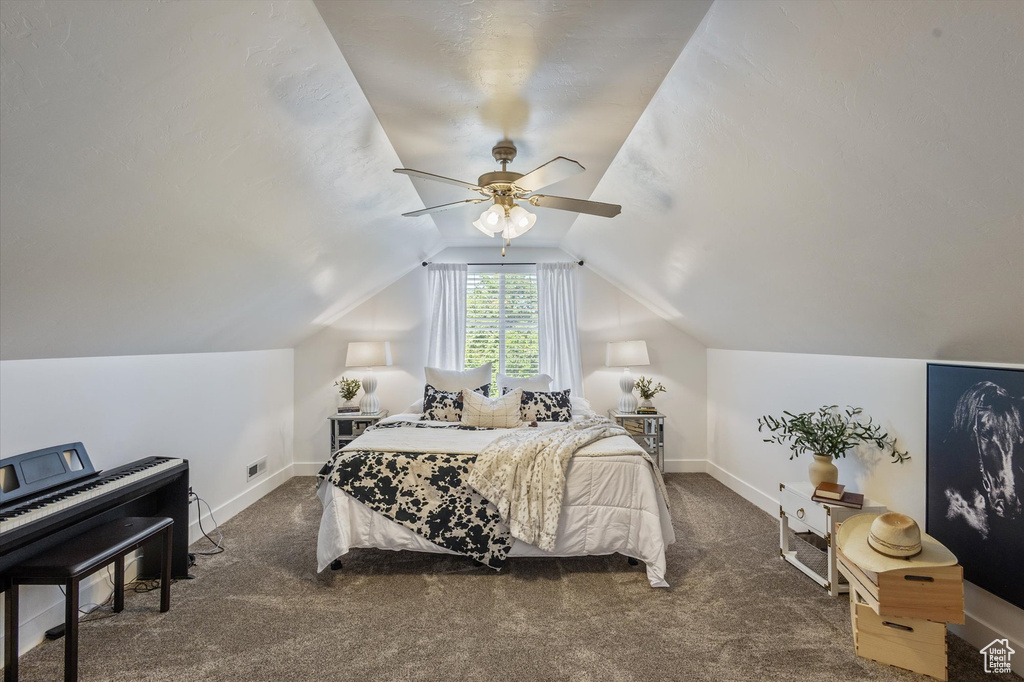 Carpeted bedroom featuring vaulted ceiling, baseboards, and a ceiling fan