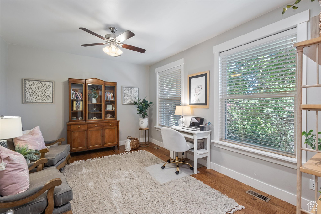 Office space featuring ceiling fan, wood finished floors, and baseboards