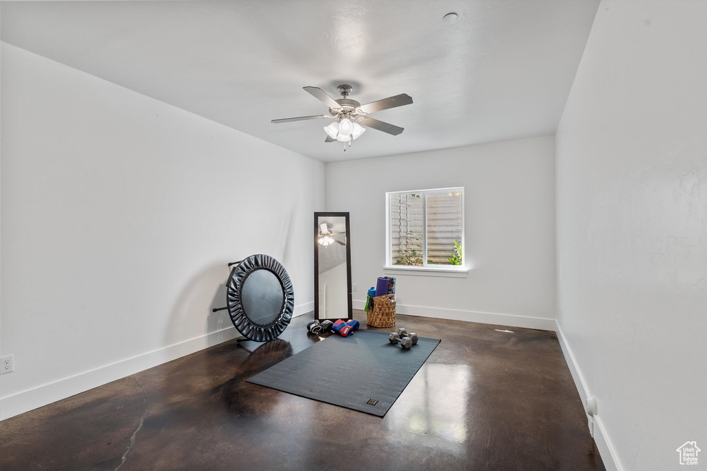 Exercise room featuring ceiling fan and baseboards