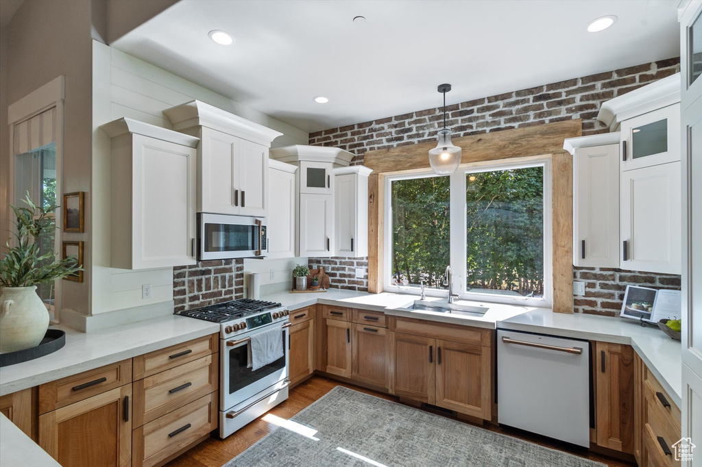 Kitchen with dishwasher, gas stove, a sink, tasteful backsplash, and recessed lighting